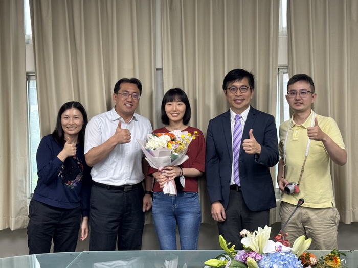 The faculty from the Department of Industrial Engineering and Engineering Management presents the bouquet to Ms. Jiang.