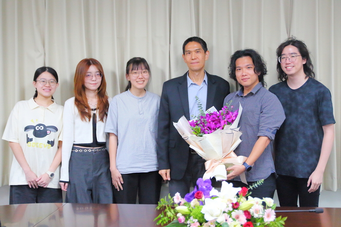 Prof. Chu Chih-Hsing accepts the bouquet presented by the students from the Department of IEEM.
