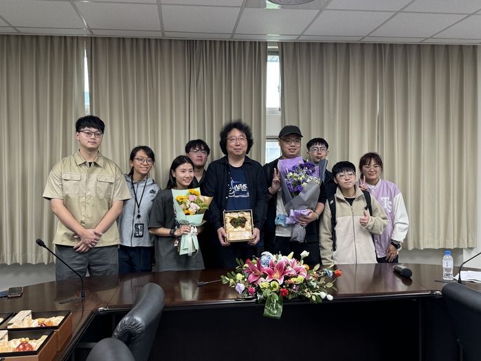 Prof. Morikawa Kyojiro, the recipient of the Outstanding Teaching award, accepts the bouquet presented by students from the Institute of NEMS.