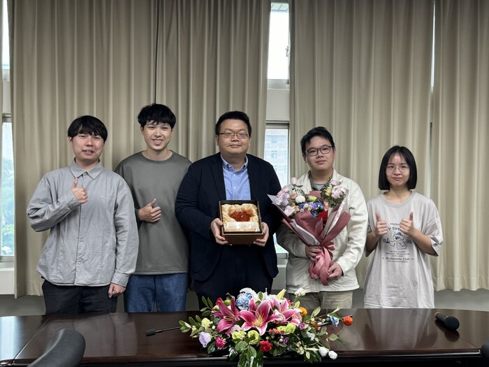 Prof. Lin Yu-Hsun, the recipient of the New Faculty Research award, accepts the bouquet presented by students from the Department of IEEM.