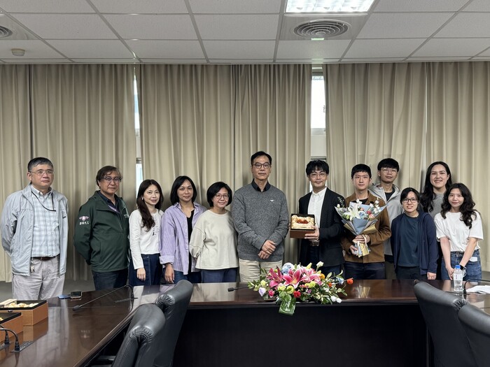 Prof. Chou Ho-Hsiu, the recipient of the Outstanding Academia-Industry Research award, accepts the bouquet presented by students from the Department of CHE.